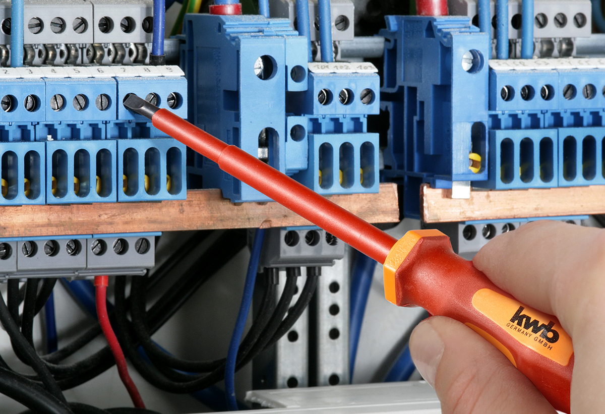 Στη φωτογραφία απεικονίζεται ένα χέρι με το κατσαβίδι που φτιάχνει έναν πίνακα